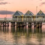 The iconic blue Busselton Jetty buildings at sunset